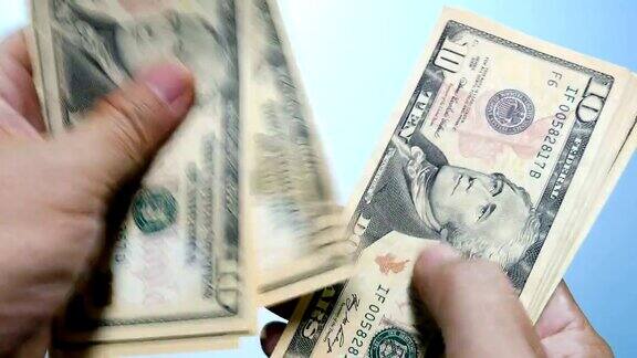 手里数着钱新的10美元美钞特写的一个商人的手数着小的美国钞票钞票