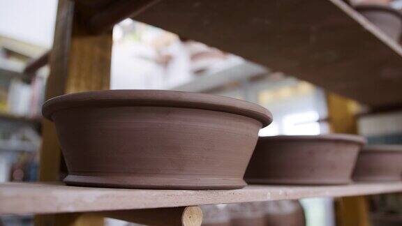 陶艺工作室架子上的手工陶土碗组