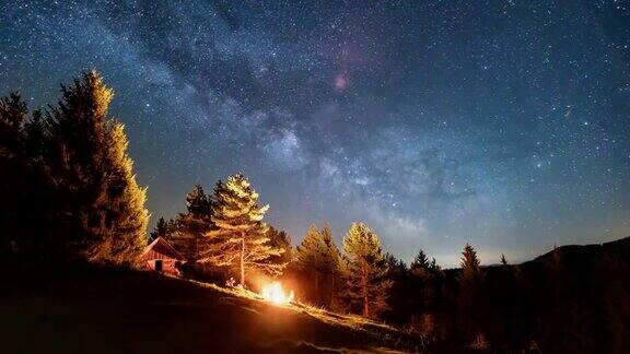 神奇的星星天空与银河银河在野生森林的自然和朋友坐在篝火在繁星的夜晚天文学时间流逝