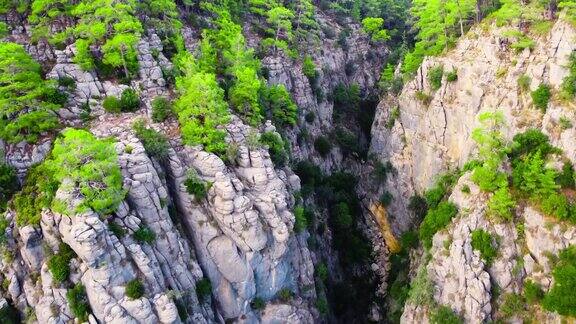 山脉山谷景观与森林和树木史诗般的无人机飞行在巨大壮观的岩石巨大的石头结构戏剧性的地质奇迹鸟瞰4k