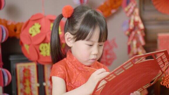 年轻的女孩在家里制作传统的中国新年工艺品来庆祝