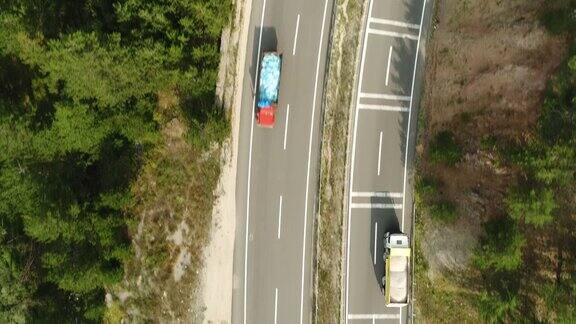 卡车开着行驶在森林柏油路上的航拍镜头高速公路卡车交通