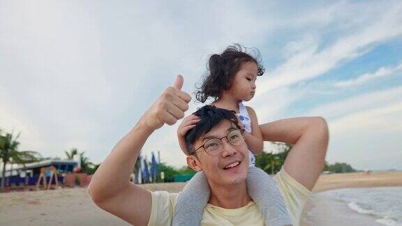 亚洲父亲快乐享受和他的女儿在海滩上玩
