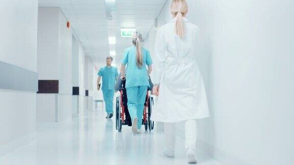 随后拍摄的女护士移动病人在轮椅通过医院走廊做程序明亮的现代医院和友好的员工