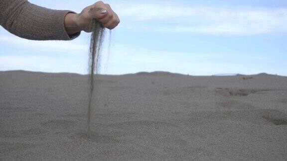让沙子从指缝中靠近女人的手拿起了沙子