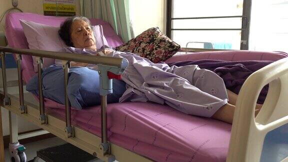 年老的女病人躺在医院的病床上