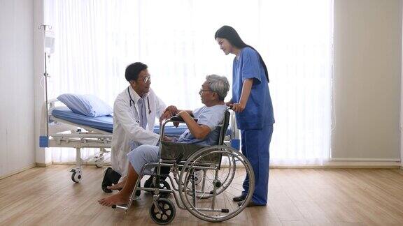 医生和理疗师与坐在轮椅上的老年病人交谈