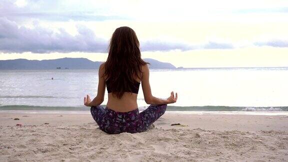 瑜伽冥想在莲花姿势在海滩上