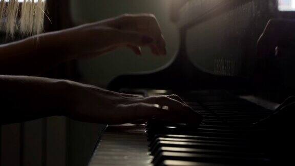 钢琴家的手打开三角钢琴开始播放音乐的近距离慢动作