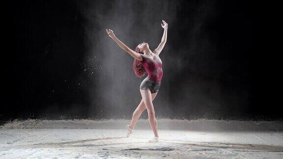 美丽的芭蕾舞演员在演播室与粉雪跳舞慢动作