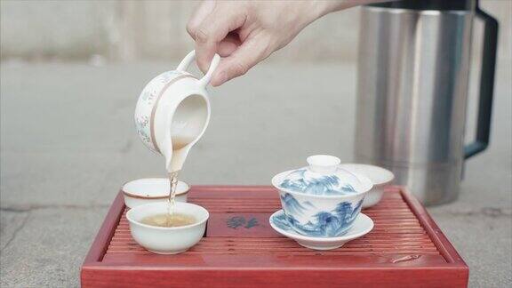 传统的中国茶道视频男子手套中国茶杯特写中国的饮茶仪式倒茶喝