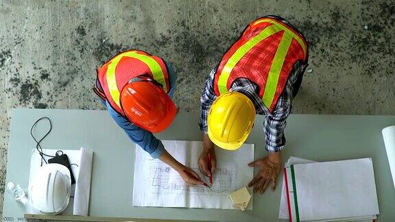 工程师和工地经理在施工现场看图纸的俯视图为重工业团队合作的经营理念