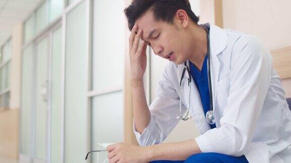 年轻的亚洲医生劳累过度男性成熟的医护人员坐着看着很紧张