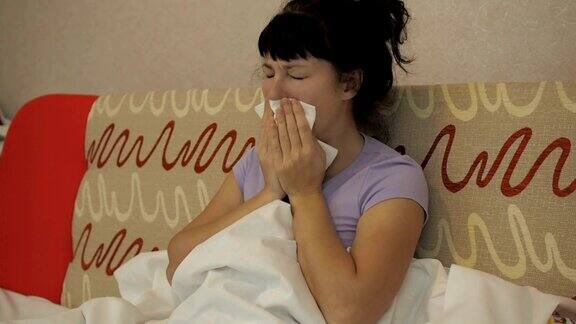 年轻的生病妇女在家里的沙发上咳嗽女孩出现咳嗽和拿纸巾、流感症状医疗保健和医疗理念感冒是流感的感染哮喘发作