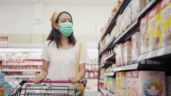亚洲妇女戴防护口罩和购物