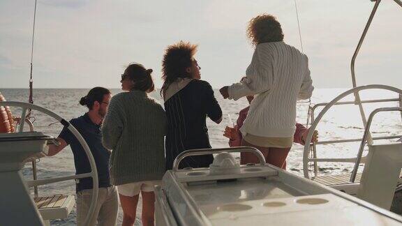 日落时分年轻人在船上的甲板上举行聚会