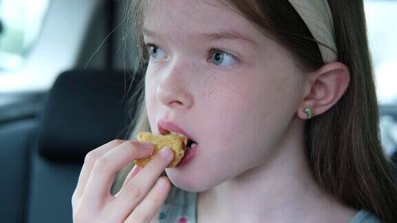 小女孩在车里吃鸡块快餐