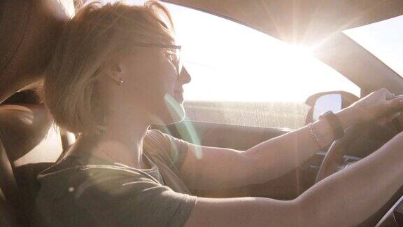年轻女子在夕阳下开车