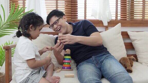 4K亚洲父亲玩木制玩具与小女儿在家