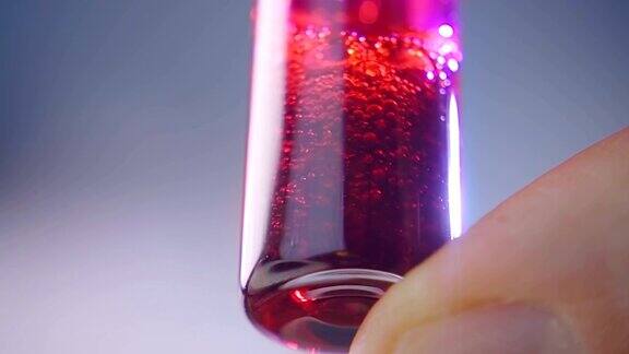 用手指摇动装有红色药液的玻璃瓶