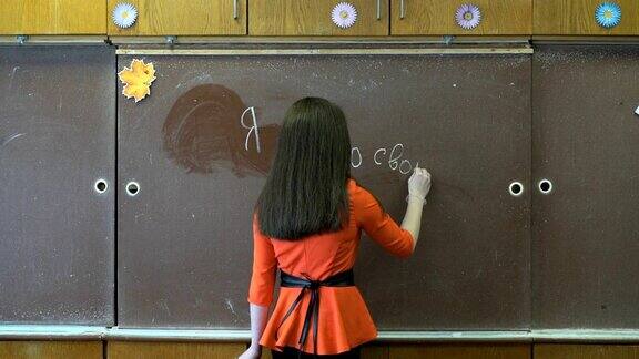 女孩用粉笔在黑板上写字