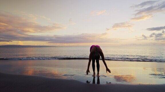 日落时在海边练习瑜伽的女人