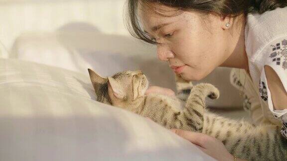 卧室白色的床上猫拥抱着她的女人