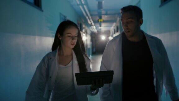 两个急诊医生在医院走廊里用着平板电脑