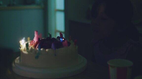 快乐女孩吹灭生日蛋糕上的蜡烛