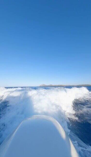 一艘游船在蓝色的水面上高速航行形成的水迹令人惊叹意大利撒丁岛翡翠海岸