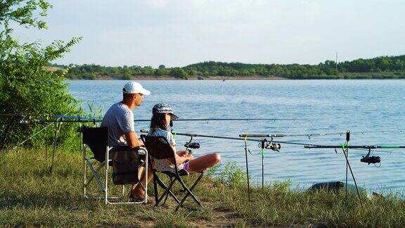 父亲和女儿在河边钓鱼聊天
