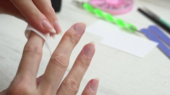 一个女孩在涂指甲油前用一种特殊的液体除去指甲准备修指甲