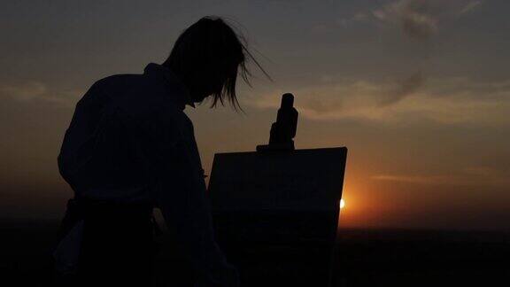一个女孩在日落时画的剪影