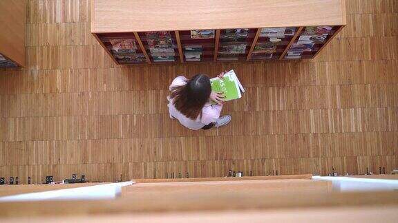 一个学生在图书馆阅读科学文章的鸟瞰图