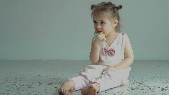 学龄前女孩吃棒棒糖在家上学