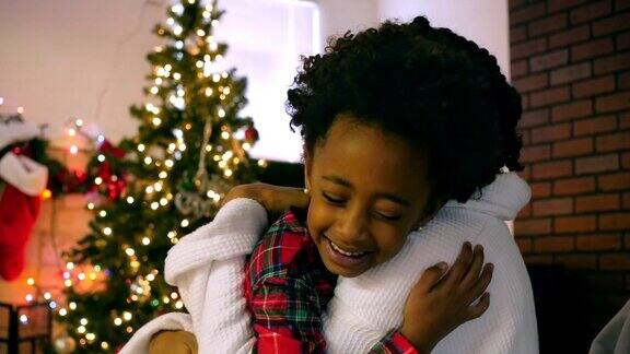 感谢非洲裔美国女孩拥抱妈妈在圣诞节的早晨