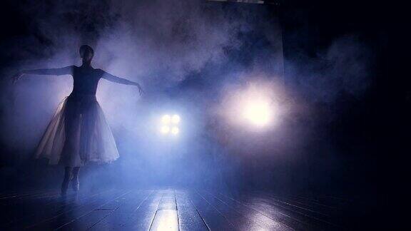 一位女舞者匆匆穿过黑暗的舞台