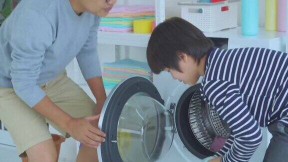 一个男孩和他的父亲一起做家务他们一起愉快地打扫了家