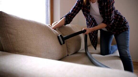 女人在打扫沙发沙发用吸尘器