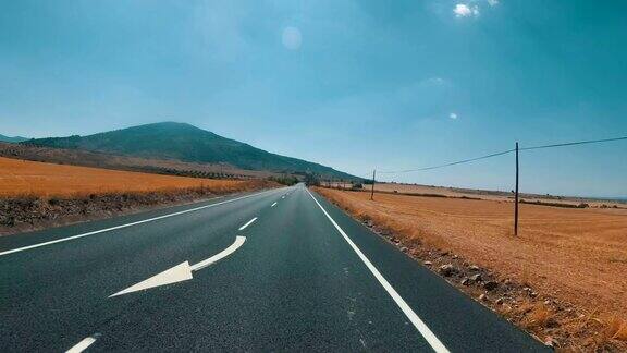 在西班牙骑摩托车的人在风景优美的沙漠和空旷的道路上第一个人的观点