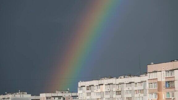 城市房屋上方阴天的巨大彩虹
