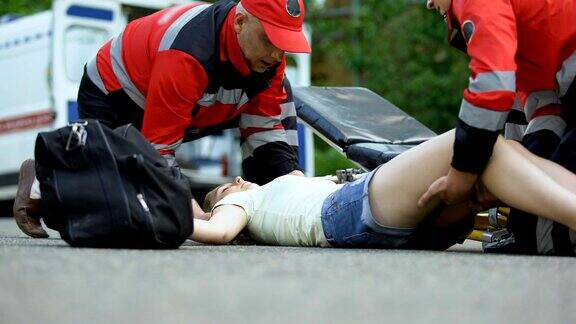 救护人员用担架把昏迷的女孩抬到救护车上