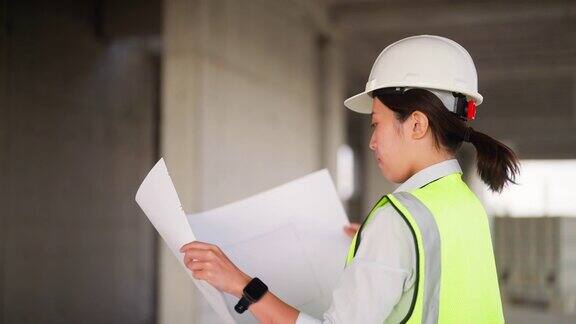 年轻的女工程师在建筑工地设计图纸