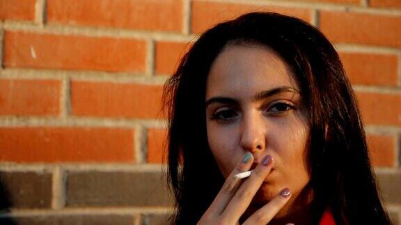 近距离的肖像一个年轻女子吸烟看镜头