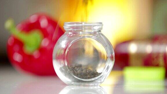 黑花椒落在玻璃罐中