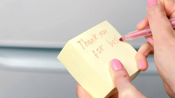 特写的女人的手写在黄色贴纸纸上的文字感谢你最好的夜晚