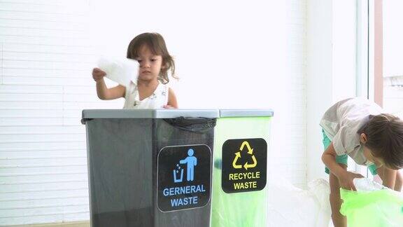 ิ哥哥和妹妹帮助把塑料瓶分成可回收的垃圾箱
