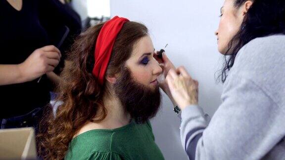 造型师把假胡子贴在女孩脸上在剧院的化妆间里