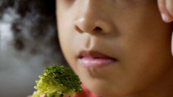 一个小孩用叉子拿着新鲜的绿色西兰花美味的蔬菜