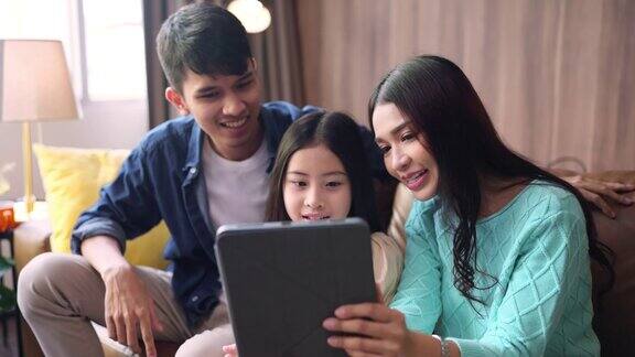 幸福亚洲家庭的女儿一起呆在家里用平板电脑自拍或视频打电话给祖父母进行远距离通信在客厅里一起自拍家人的照片